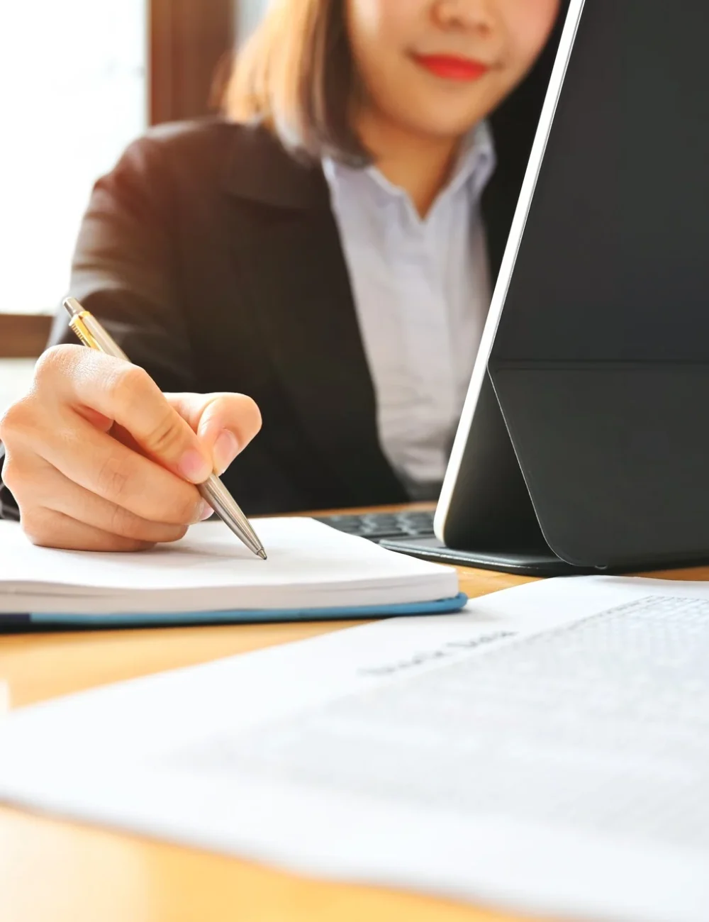 Audit business woman working with notebook and tablet on desk.